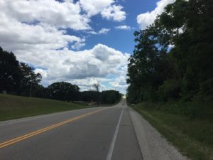 A long, mostly empty, two-laned road stretching off into the distance.