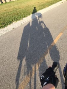 A shadow silhouette of loaded bike and rider.